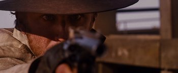 Movie still from “3:10 to Yuma” (2007), directed by James Mangold – A person holding a gun; Extreme Close Up shot, Over the shoulder angle