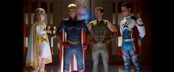 Movie still from “The Boys” (2019), created by Eric Kripke – A group of men standing next to each other in costumes; Medium shot, Low angle