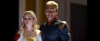 Movie still from “The Boys” (2019), created by Eric Kripke – A man with blonde hair and a star on his chest; Medium shot, Over the shoulder angle