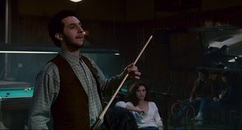 Movie still from “The Color of Money” (1986), directed by Martin Scorsese – A man holding a wooden stick in front of a woman; Medium shot, Over the shoulder angle