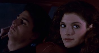 Movie still from “The Color of Money” (1986), directed by Martin Scorsese – A man and a woman sitting in a car looking at the camera; Close Up shot, Over the shoulder angle
