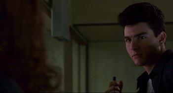 Movie still from “The Color of Money” (1986), directed by Martin Scorsese – A young man holding a cell phone in front of a bathroom mirror; Close Up shot, Over the shoulder angle