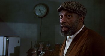 Movie still from “The Color of Money” (1986), directed by Martin Scorsese – An older man wearing a hat and a brown jacket; Close Up shot, Low angle