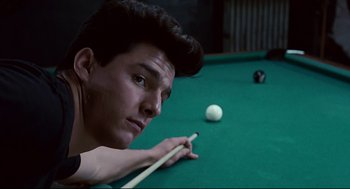 Movie still from “The Color of Money” (1986), directed by Martin Scorsese – A young man holding a pool stick on a pool table; Close Up shot, Over the shoulder angle
