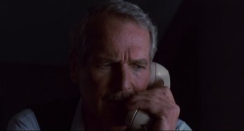 Movie still from “The Color of Money” (1986), directed by Martin Scorsese – An older man holding a phone up to his ear; Close Up shot, Low angle