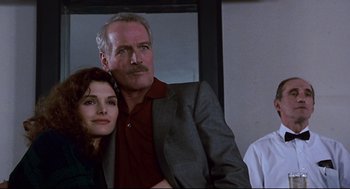 Movie still from “The Color of Money” (1986), directed by Martin Scorsese – A man and a woman pose for a picture; Close Up shot, Low angle