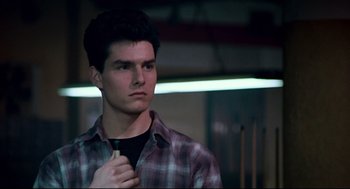 Movie still from “The Color of Money” (1986), directed by Martin Scorsese – A man in a plaid shirt is holding his tie; Close Up shot, Over the shoulder angle