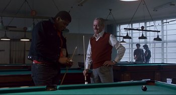 Movie still from “The Color of Money” (1986), directed by Martin Scorsese – Two men are playing a game of billiards together; Medium shot, Low angle
