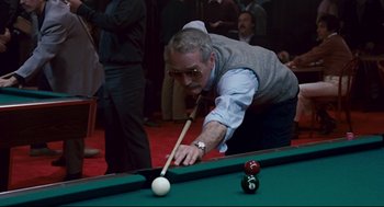 Movie still from “The Color of Money” (1986), directed by Martin Scorsese – An older man is playing a game of billiards; Medium shot, Over the shoulder angle