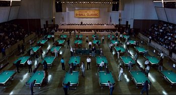 Movie still from “The Color of Money” (1986), directed by Martin Scorsese – A group of people standing around a pool table; Extreme Wide shot, High angle