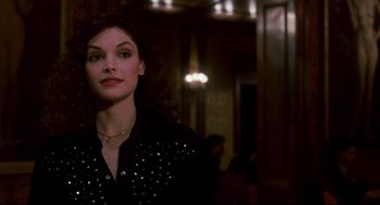 Movie still from “The Color of Money” (1986), directed by Martin Scorsese – A woman in a black shirt is standing in a dark room; Close Up shot, Over the shoulder angle