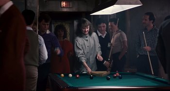 Movie still from “The Color of Money” (1986), directed by Martin Scorsese – A group of people standing around a pool table; Medium shot, High angle