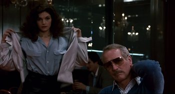 Movie still from “The Color of Money” (1986), directed by Martin Scorsese – A man and a woman in a room with lights in the background; Medium shot, Low angle