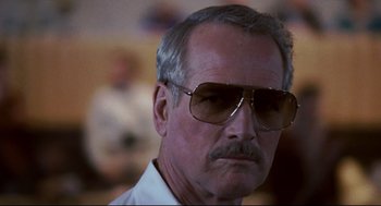 Movie still from “The Color of Money” (1986), directed by Martin Scorsese – An older man wearing sunglasses and a white shirt; Close Up shot, Low angle