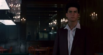 Movie still from “The Color of Money” (1986), directed by Martin Scorsese – A man in a suit and striped shirt standing in front of a table; Medium shot, Over the shoulder angle