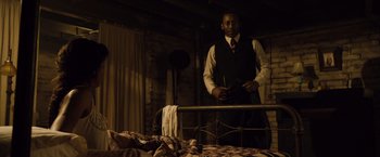 Movie still from “The Curious Case of Benjamin Button” (2008), directed by David Fincher – A man standing in front of an unmade bed; Medium shot, Low angle