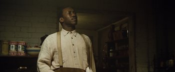 Movie still from “The Curious Case of Benjamin Button” (2008), directed by David Fincher – A man wearing a shirt and suspenders looking up; Medium shot, Low angle