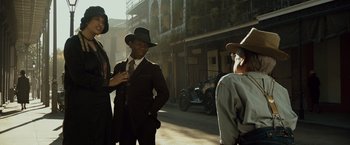 Movie still from “The Curious Case of Benjamin Button” (2008), directed by David Fincher – A group of people standing on the side of a street; Medium shot, Low angle