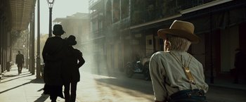 Movie still from “The Curious Case of Benjamin Button” (2008), directed by David Fincher – Two men in hats are standing on a street; Wide shot, Low angle