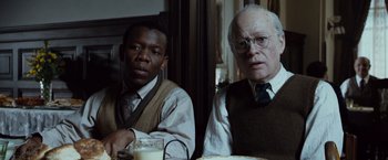 Movie still from “The Curious Case of Benjamin Button” (2008), directed by David Fincher – Two men sitting at a table with a glass of milk in front of them; Close Up shot, Over the shoulder angle