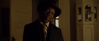 Movie still from “The Curious Case of Benjamin Button” (2008), directed by David Fincher – A man wearing a suit and hat in a dark room; Close Up shot, Low angle