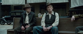 Movie still from “The Curious Case of Benjamin Button” (2008), directed by David Fincher – Two older men sitting next to each other on a bench; Medium shot, Low angle