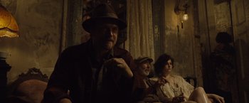 Movie still from “The Curious Case of Benjamin Button” (2008), directed by David Fincher – A group of people sitting next to each other in a room; Medium shot, Low angle