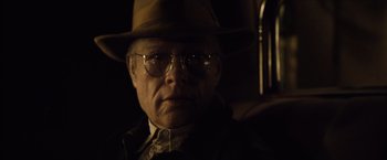 Movie still from “The Curious Case of Benjamin Button” (2008), directed by David Fincher – An older man wearing a hat and glasses; Close Up shot, Over the shoulder angle