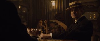 Movie still from “The Curious Case of Benjamin Button” (2008), directed by David Fincher – A group of people sitting at a table with drinks; Medium shot, Over the shoulder angle