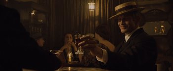 Movie still from “The Curious Case of Benjamin Button” (2008), directed by David Fincher – A group of people sitting at a table drinking wine; Medium shot, Over the shoulder angle