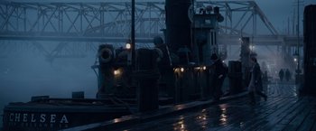 Movie still from “The Curious Case of Benjamin Button” (2008), directed by David Fincher – A man standing on a dock next to a boat in the rain; Extreme Wide shot, High angle