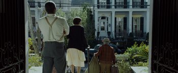 Movie still from “The Curious Case of Benjamin Button” (2008), directed by David Fincher – A group of people walking down a street; Wide shot, Low angle