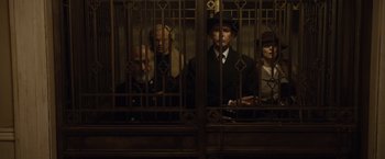 Movie still from “The Curious Case of Benjamin Button” (2008), directed by David Fincher – A group of people sitting next to each other in front of a window; Wide shot, Low angle