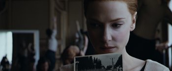 Movie still from “The Curious Case of Benjamin Button” (2008), directed by David Fincher – A woman holding an old picture of a forest; Close Up shot, Over the shoulder angle