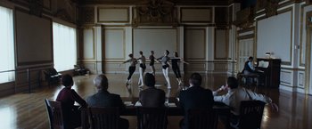 Movie still from “The Curious Case of Benjamin Button” (2008), directed by David Fincher – A group of dancers performing on a stage in front of a crowd of onlookers; Wide shot, Over the shoulder angle