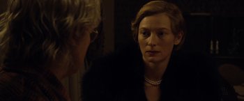 Movie still from “The Curious Case of Benjamin Button” (2008), directed by David Fincher – A woman wearing a black jacket and a pearl necklace; Close Up shot, Over the shoulder angle
