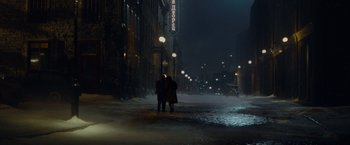Movie still from “The Curious Case of Benjamin Button” (2008), directed by David Fincher – Two people standing on the side of the street at night; Extreme Wide shot, High angle
