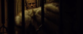 Movie still from “The Curious Case of Benjamin Button” (2008), directed by David Fincher – A man with glasses is looking through a window; Close Up shot, Over the shoulder angle