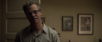 Movie still from “The Curious Case of Benjamin Button” (2008), directed by David Fincher – A man with glasses standing in front of a painting; Close Up shot, Over the shoulder angle