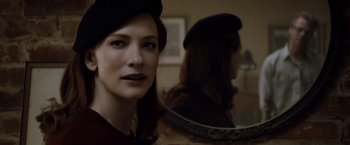 Movie still from “The Curious Case of Benjamin Button” (2008), directed by David Fincher – A person wearing a hat near a mirror; Close Up shot, Over the shoulder angle
