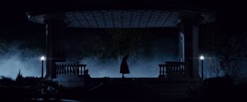 Movie still from “The Curious Case of Benjamin Button” (2008), directed by David Fincher – A woman is standing on a stage in the dark; Extreme Wide shot, Low angle