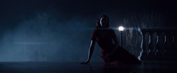 Movie still from “The Curious Case of Benjamin Button” (2008), directed by David Fincher – A woman sitting on the ground in front of a street light; Wide shot, High angle