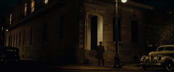 Movie still from “The Curious Case of Benjamin Button” (2008), directed by David Fincher – A man standing in front of a door at night; Extreme Wide shot, Low angle