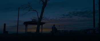 Movie still from “The Curious Case of Benjamin Button” (2008), directed by David Fincher – A man standing next to a tree at night; Extreme Wide shot, Low angle