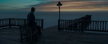 Movie still from “The Curious Case of Benjamin Button” (2008), directed by David Fincher – A man sitting on top of a wooden pier; Wide shot, High angle
