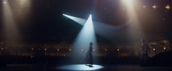 Movie still from “The Curious Case of Benjamin Button” (2008), directed by David Fincher – A person standing on a stage with a light shining on them; Extreme Wide shot, Low angle