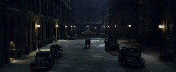 Movie still from “The Curious Case of Benjamin Button” (2008), directed by David Fincher – A couple of people standing in the middle of a street; Extreme Wide shot, High angle