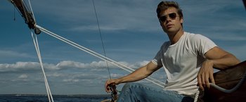 Movie still from “The Curious Case of Benjamin Button” (2008), directed by David Fincher – A man sitting on a sailboat in the water; Medium shot, Low angle