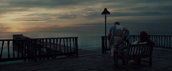 Movie still from “The Curious Case of Benjamin Button” (2008), directed by David Fincher – A person wrapped in a blanket standing on a pier; Extreme Wide shot, High angle
