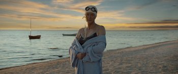 Movie still from “The Curious Case of Benjamin Button” (2008), directed by David Fincher – An older woman wrapped in a towel on the beach; Medium shot, Over the shoulder angle